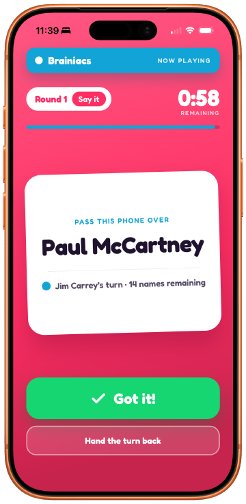 The live turn screen: a Brainiacs now-playing banner, Round 1 Say it, a 58-second countdown, a white card reading PASS THIS PHONE OVER with the name Paul McCartney, and Got it! and Hand the turn back buttons.